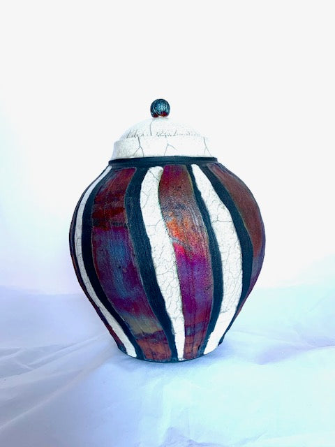 The beauty of the raku process can be seen in the color variation in the copper stripes.